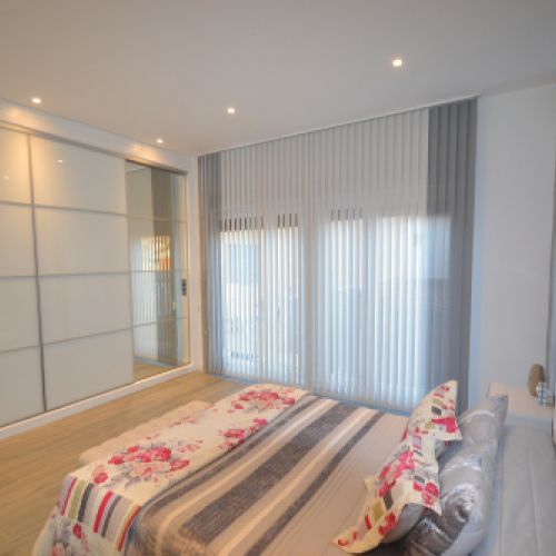 Cortina Vertical Bandalux combinada en dos colores en un dormitorio