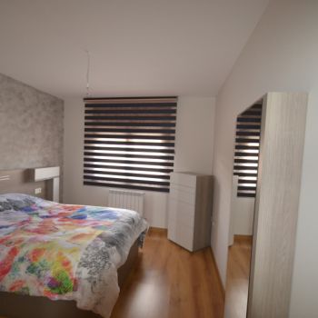 Estor Noche y Día color gris regulable en un dormitorio