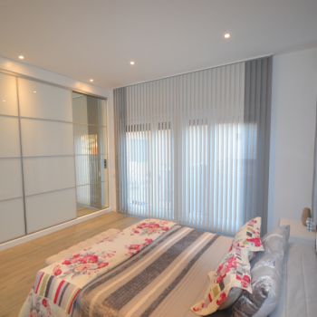 Cortina Vertical Bandalux combinada en dos colores en un dormitorio