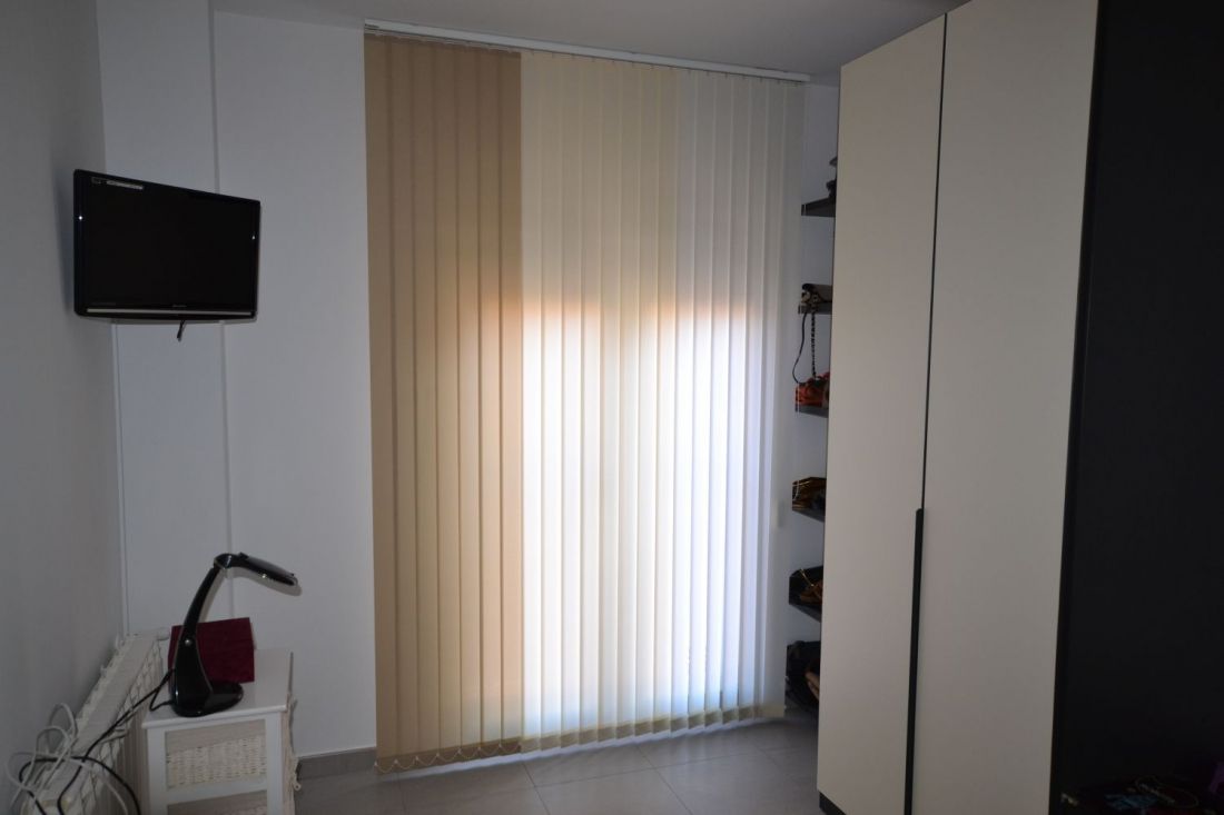 Cortinas Verticales orientables combinadas en dos colores  en un salón moderno