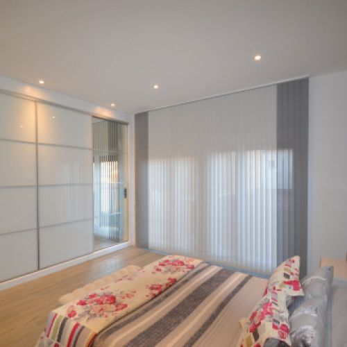 Cortina Vertical Bandalux combinada en dos colores en un dormitorio