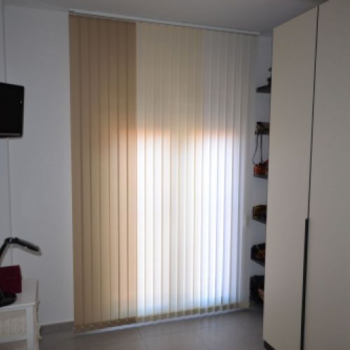 Cortinas Verticales orientables combinadas en dos colores  en un salón moderno